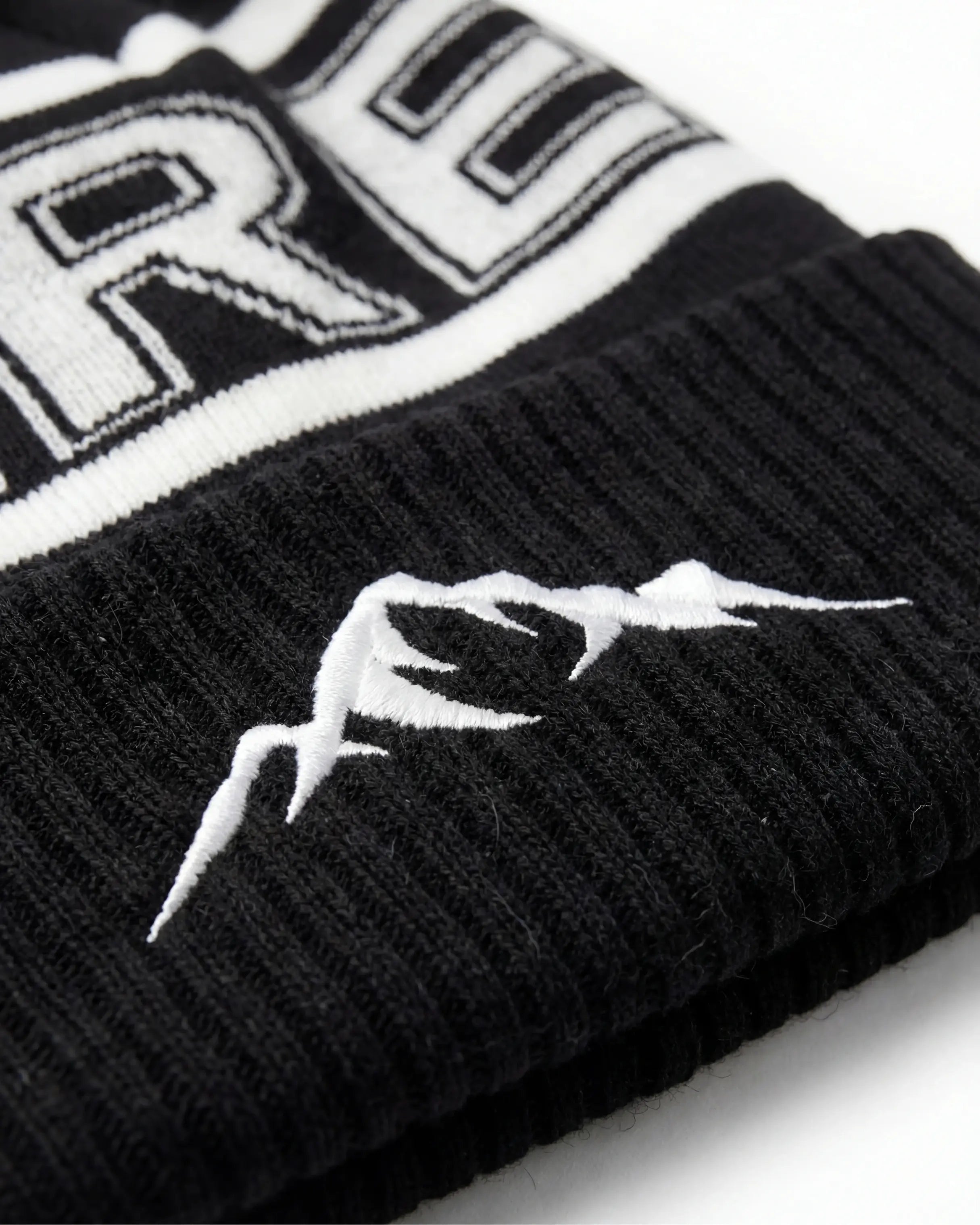 Svart Åre Mössa Med Tofs - Närbild på logotyp